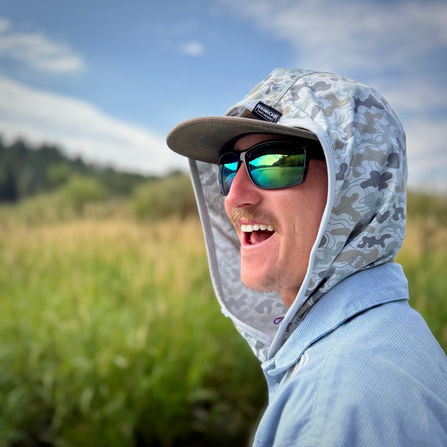 smiling young man wearing camo hood