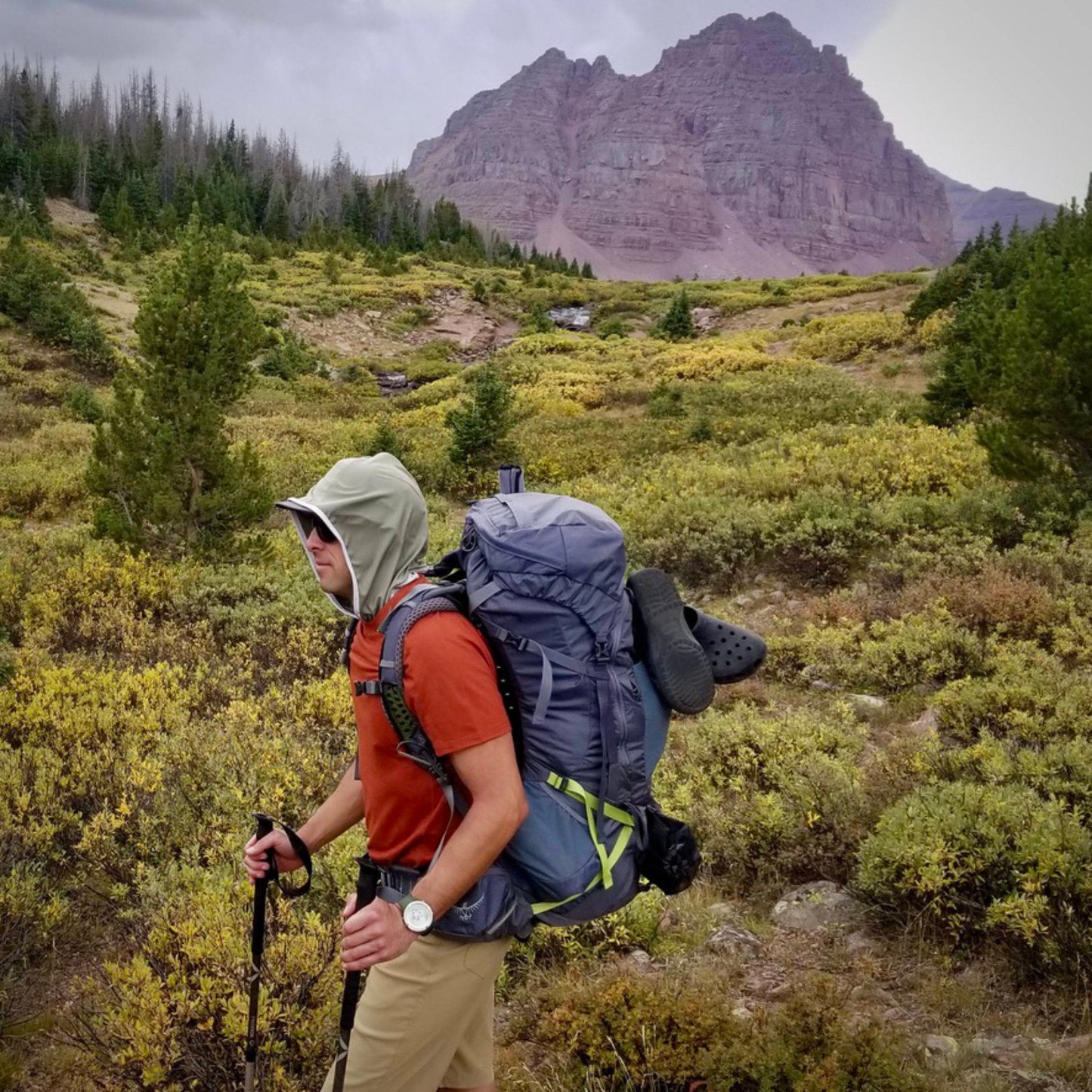 Man backpacking while wearing an olive Kinich Sun Hood.