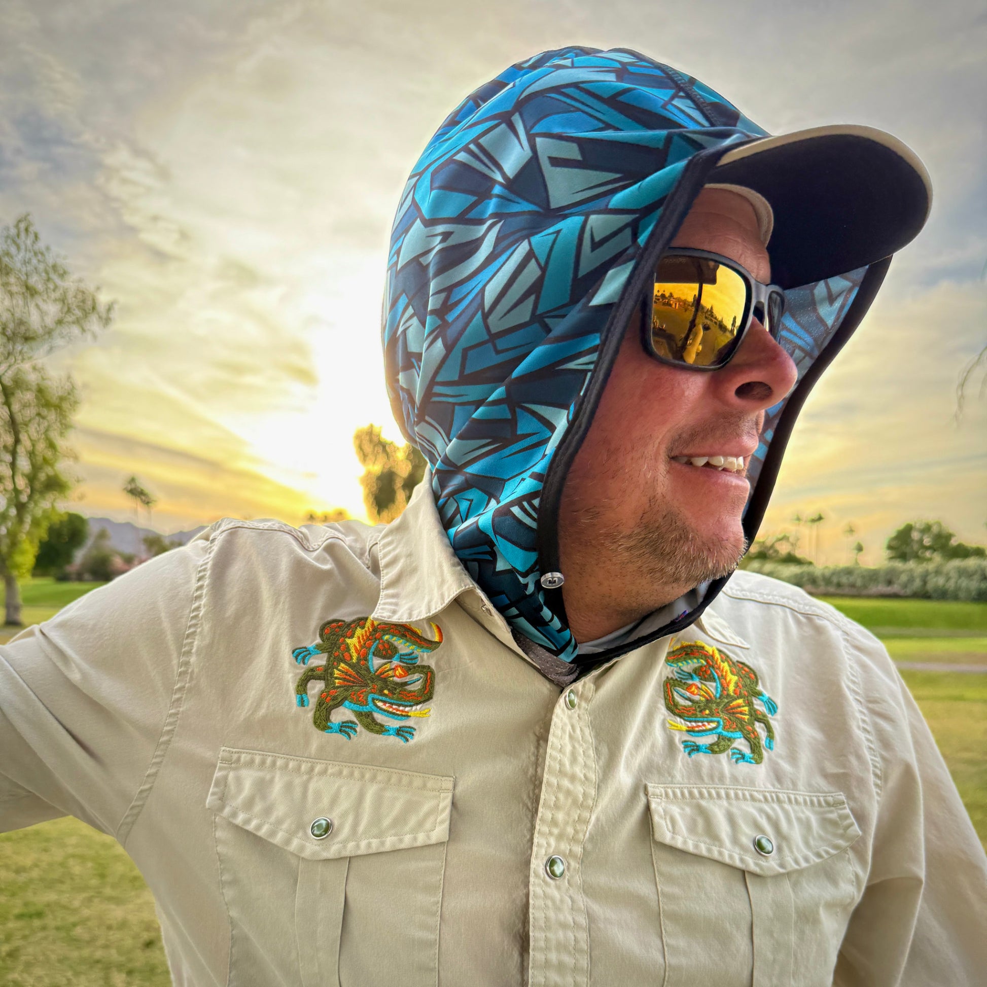 Man wearing blue geometric pattern sun hood with sunset background