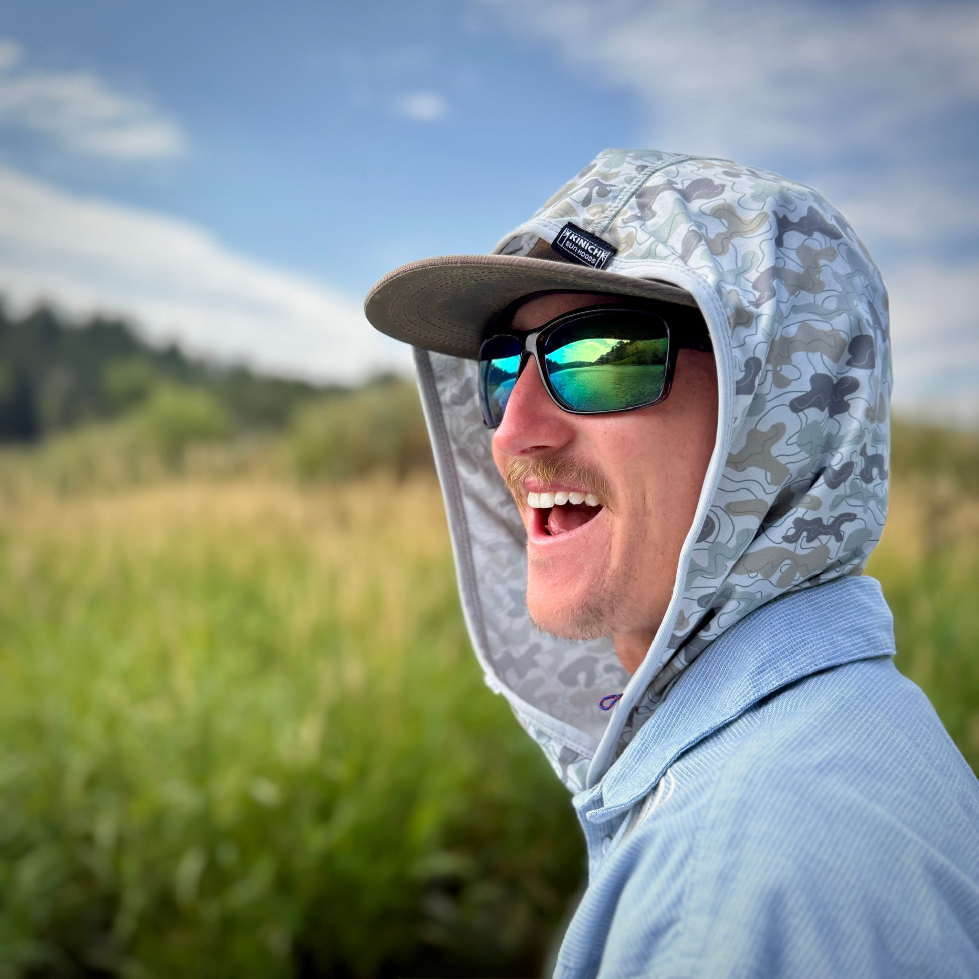 smiling young man wearing camo hood